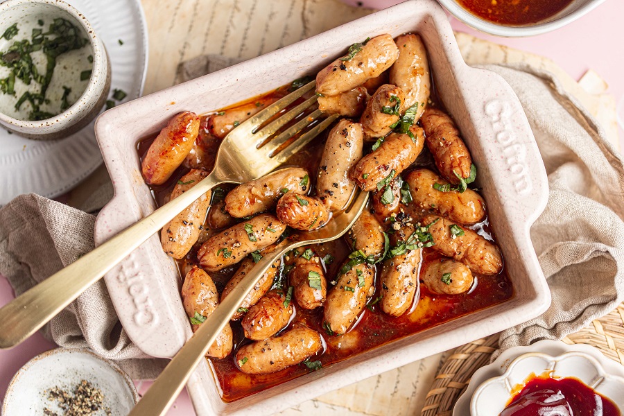 Little Smokies Party Recipe Overhead View of a Square Dish with Little Smokies with Two Forks and Topped with Parsley 