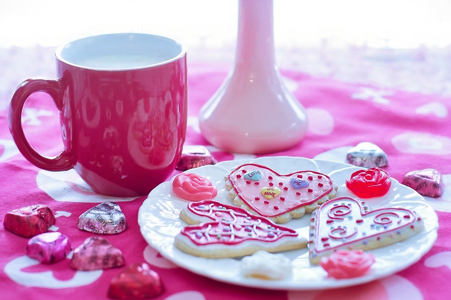 Valentines Cookies Close Up of a Plate of Heart-Shaped Cookies with a Mug of Milk