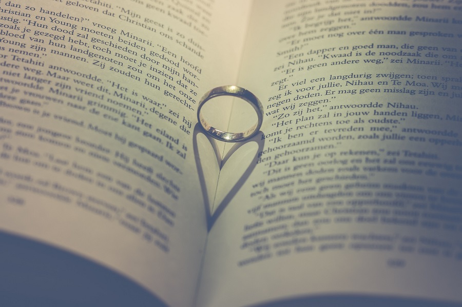 Valentines Photoshoot Ideas a Ring Sitting on the Spine of a Book Making a Heart-Shaped Shadow on the Pages