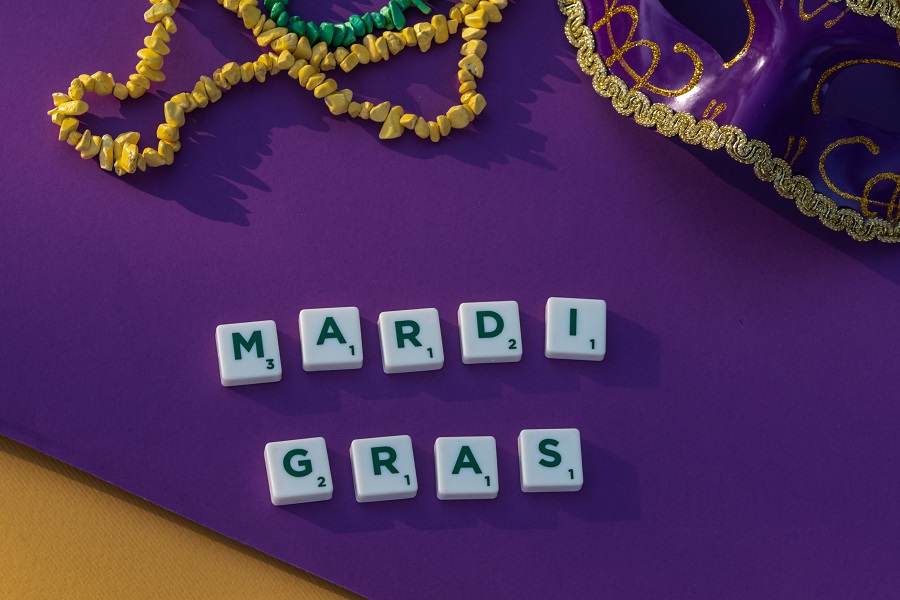 Cheap Mardi Gras Party Decorations Overhead View of Letter Tiles Spelling Out Mardi Gras with Mardi Gras Beads Next to Them