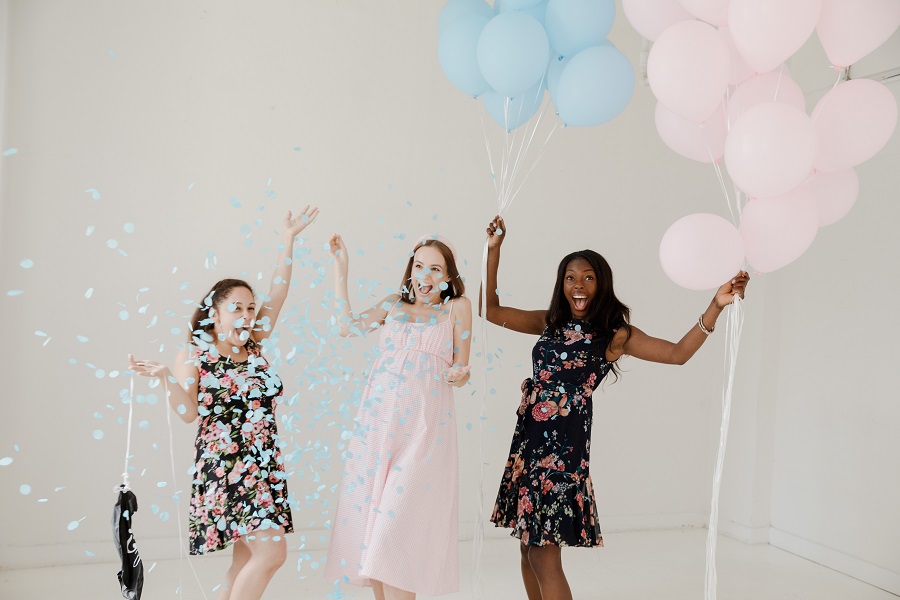 Cool Gender Reveal Ideas for Spring Woman Celebrating a Gender Reveal with Blue and Pink Balloons