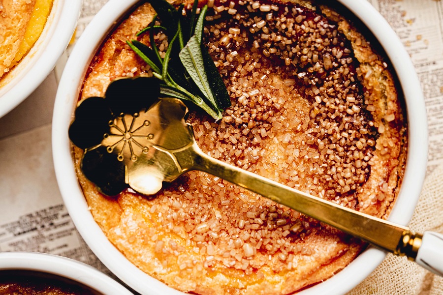 Easy No Torch Creme Brulee Recipe Overhead View of a Creme Brulee with a Spoon and a Garnish