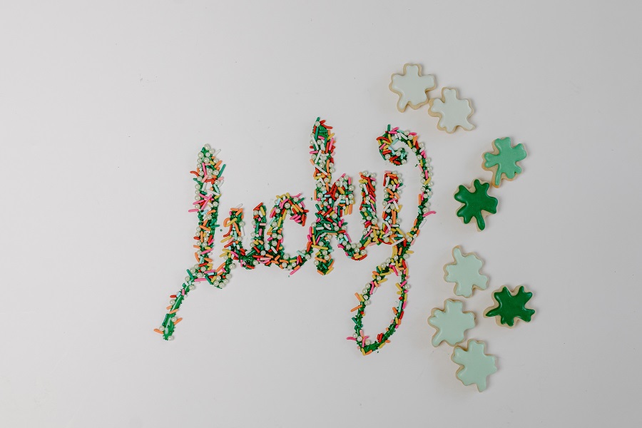 Green Recipes for St Patricks Day The Word "Lucky Spelled Out in Sprinkles on a White Background With Clover Cookies Nearby