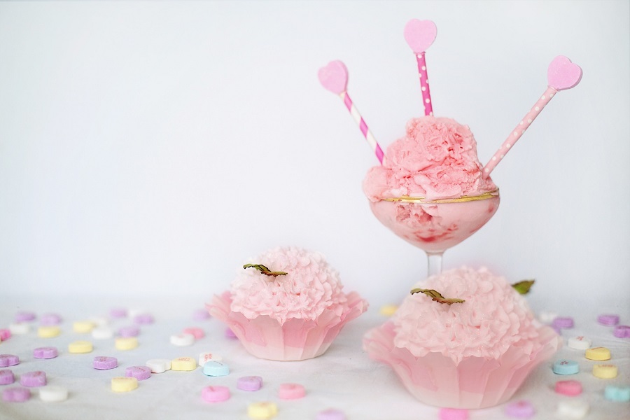 Galentine's Day Quotes Close Up of a Valentine's Day Display with Hearts on Sticks Sticking Out of a Margarita Glass and Heart Candies Scattered About