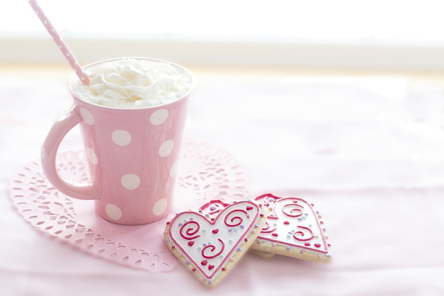 Galentine's Day Quotes for The Girls a Pink Coffee Mug Filled with Hot Chocolate and Topped with Whipped Cream Next to Two Heart-Shaped Cookies