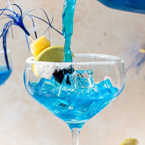 Blue Margaritas Pitcher Recipe Close Up of a Margarita Glass Being Filled with Blue Margarita