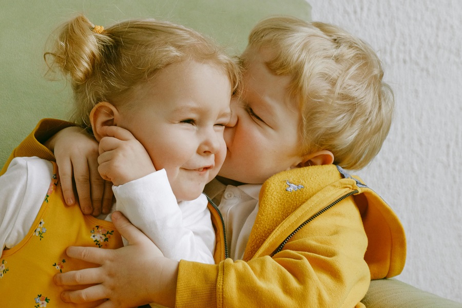 Funny Sibling Quotes for National Siblings Day Siblings Embracing on a Sofa Kissing One Another