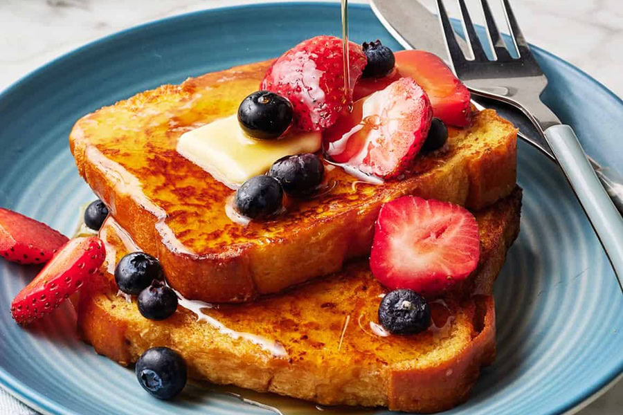 Brunch Recipes for Mother's Day French Toast on a Plate Topped with Strawberries, Syrup, and a Square of Butter