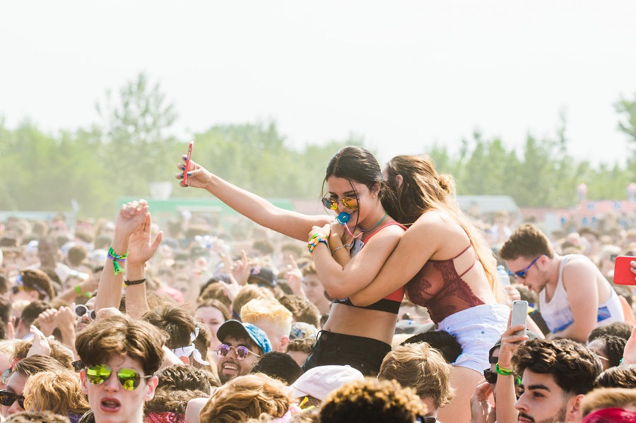 Festival Outfit Inspiration Two Women on the Shoulders of Two Different Men at a Music Festival