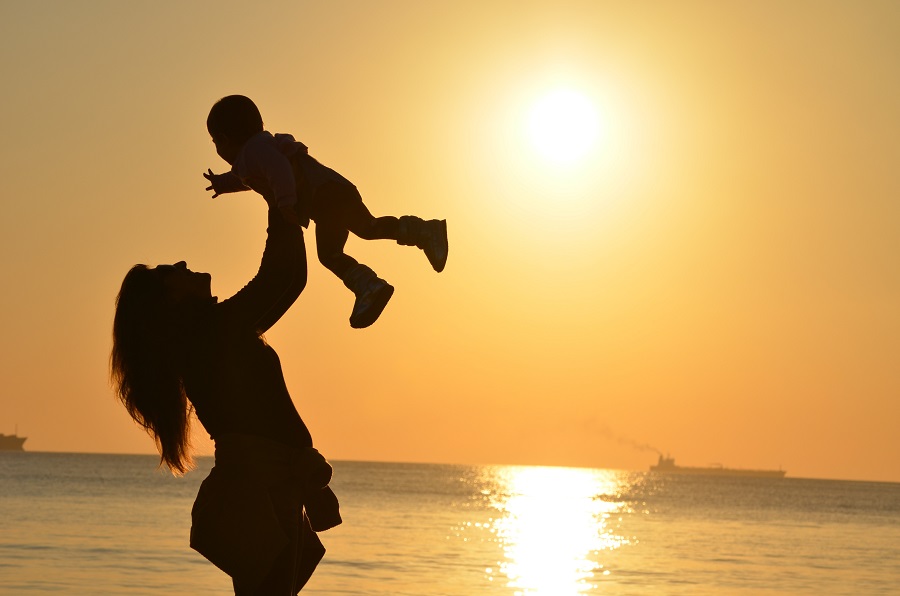 Mother's Day Brunch Decor Ideas a Mother Lifting Her Baby Up in the Air on a Beach with the Ocean in the Background and the Sun Setting