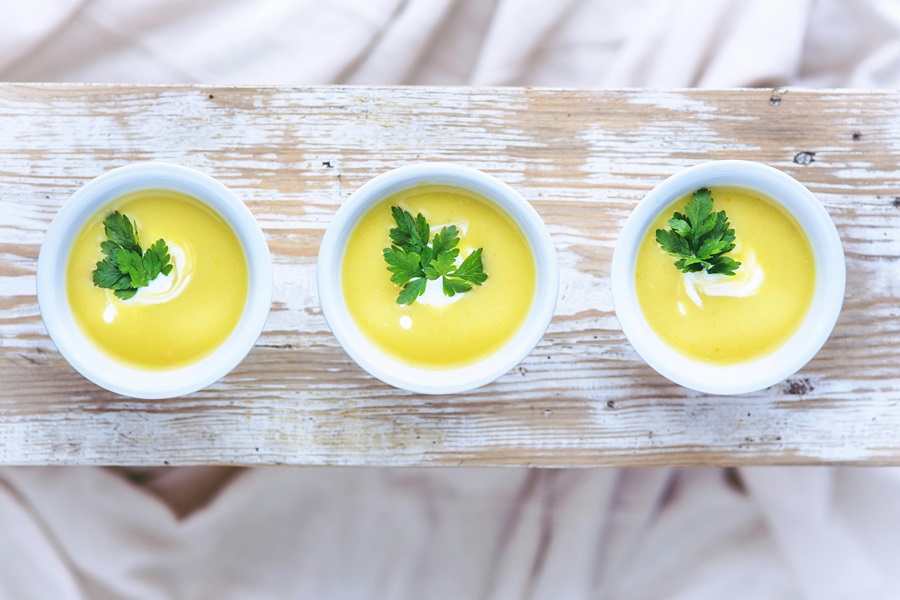 Spring Soup Recipes for a Crowd Three Small Bowls of Soup on a Wooden Plank