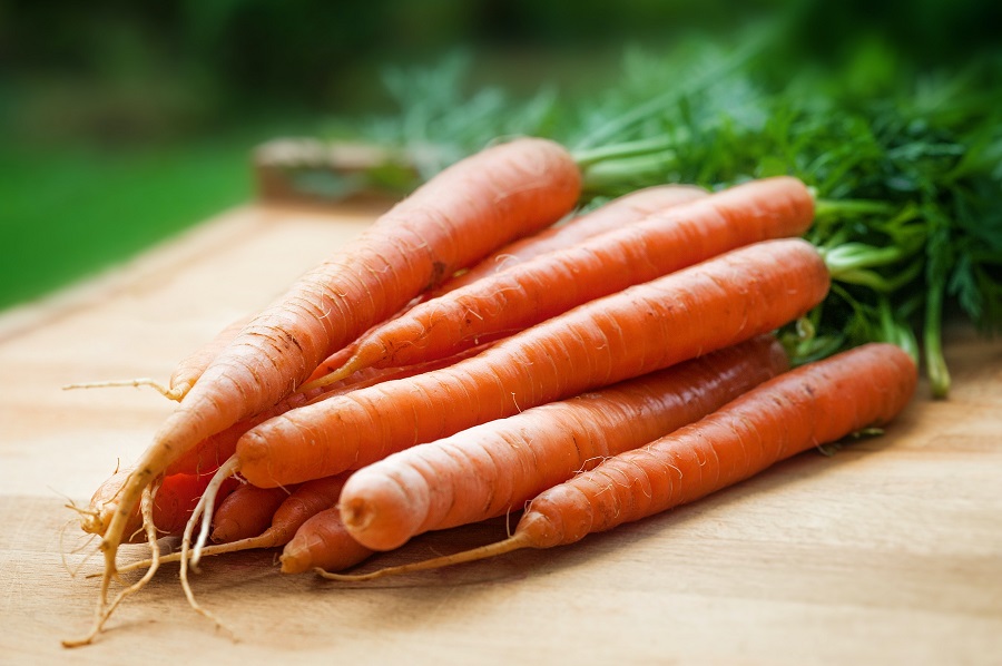 Spring Soup Recipes a Bundle of Carrots on a Wooden Cutting Board