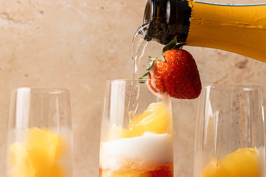 Sunrise Strawberry Mimosa Recipe Close Up of Champagne Poured into a Champagne Flute