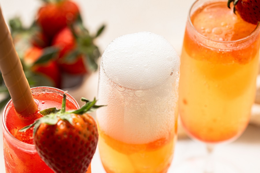 Sunrise Strawberry Mimosa Recipe Close Up of Three Champagne Flutes Garnished with Strawberries