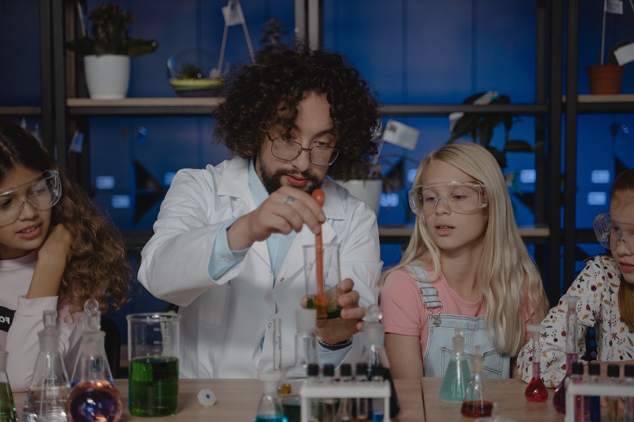 Best Teacher Appreciation Gift Ideas a Science Teacher in a Lab Coat Doing a Science Experiment with Students