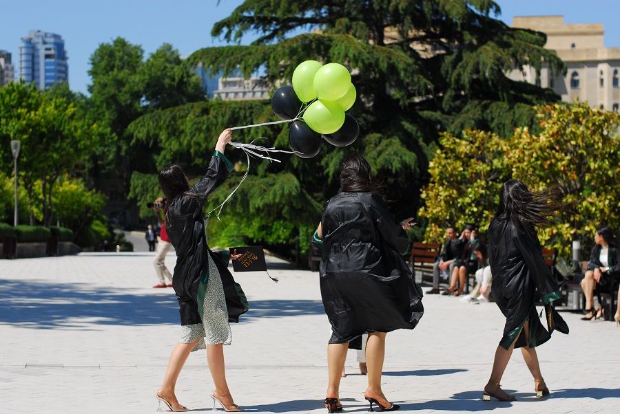 Graduation Party Ideas Grads Walking Towards a Party Holding Balloons