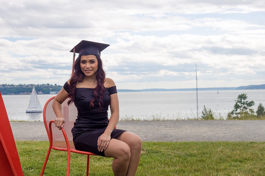 Graduation Gift Ideas a Graduate Posing for a Photo on a Chair with Her Graduation Cap On