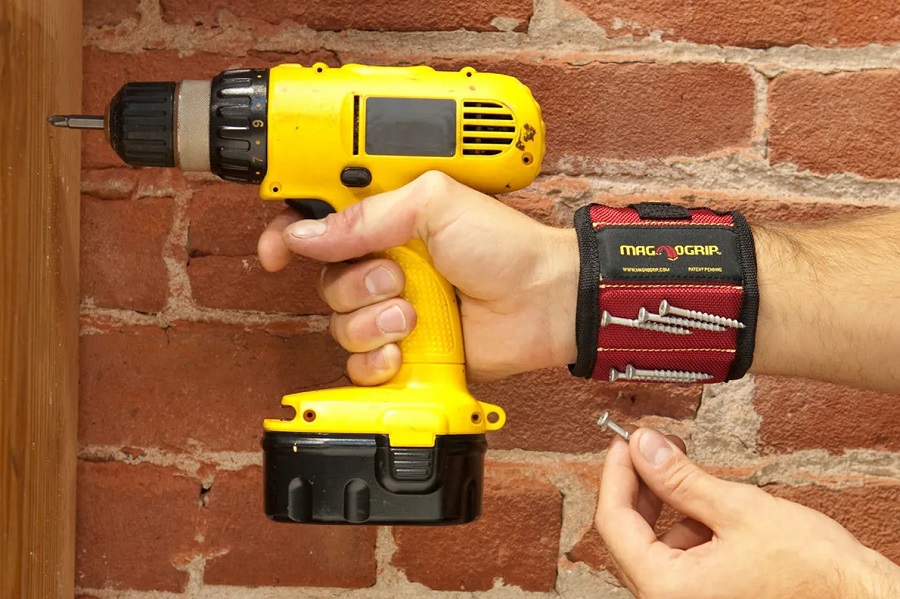 Fathers Day Gift Ideas View of a Man's Hand Holding a Power Drill and His Arm with a Magnetic Wristband on it
