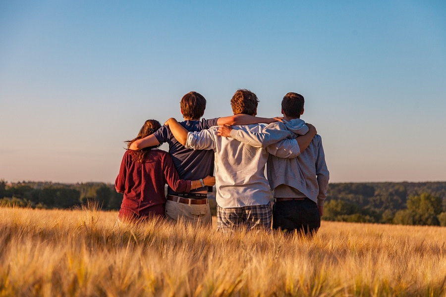 Friendship Quotes Four Friends Standing in a Line with Their Arms on Each Other's Shoulders