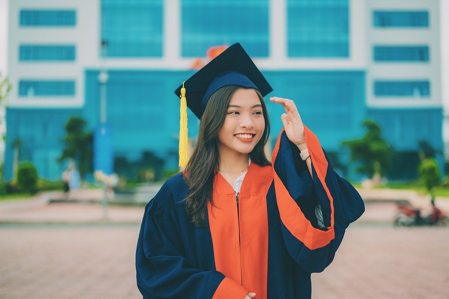 Graduation Gift Ideas a Female Graduate Posing for a Photo in Front of Her Future College