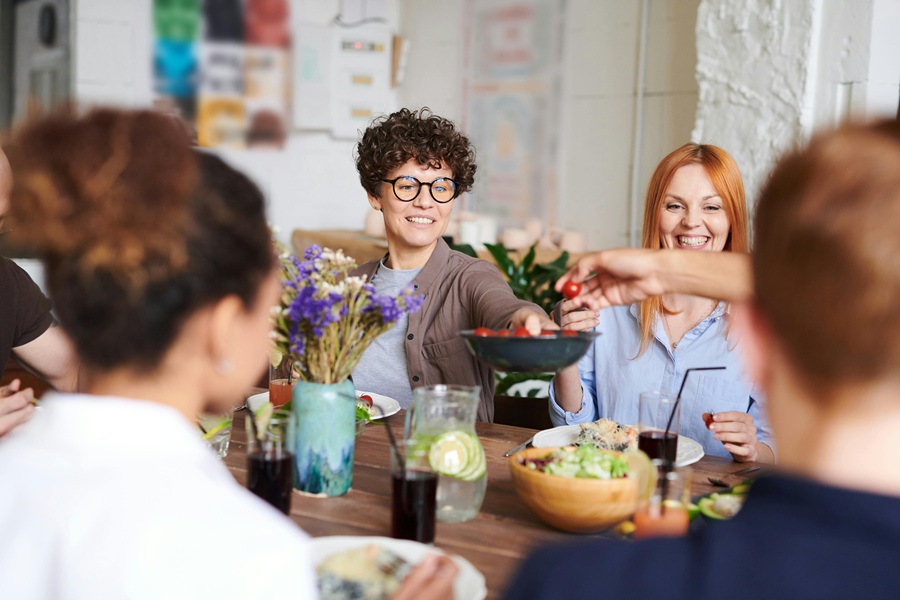 Summer Dinner Party Tips a Group of Friends Eating Dinner Together and Laughing