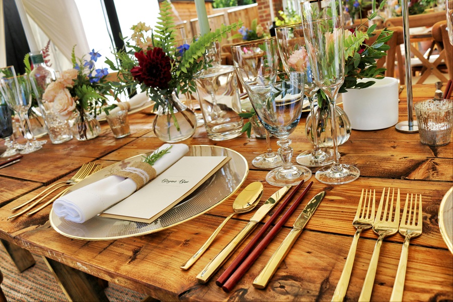 Summer Dinner Party Tips View of a Table That Has Been Set for Dinner with Cups, Plates, Napkins and Plant Centerpieces