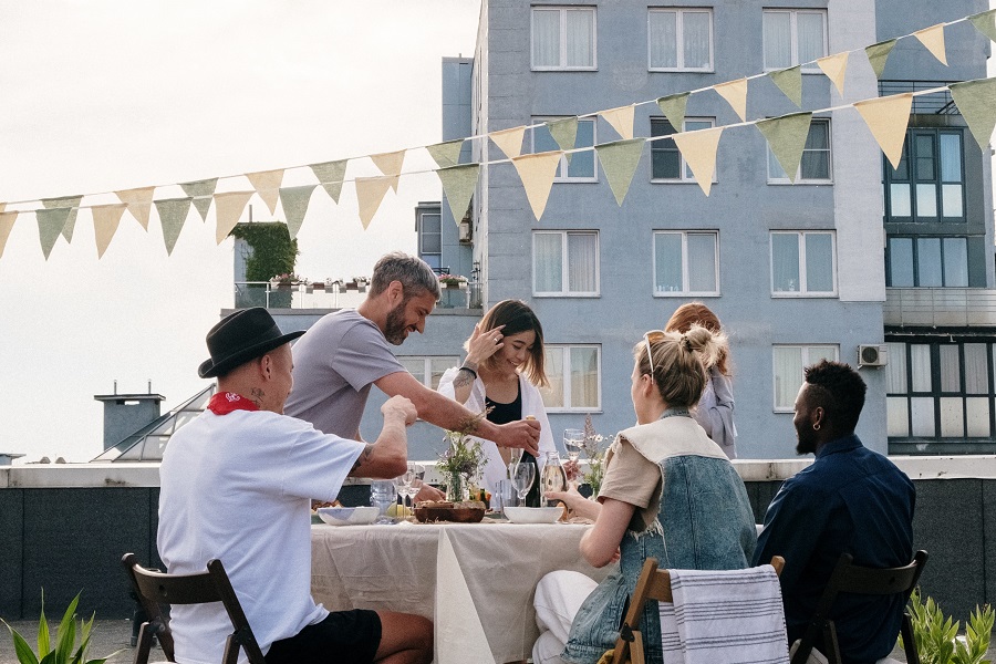 Summer Dinner Party Tips View of People Enjoying a Dinner Party on a Rooftop