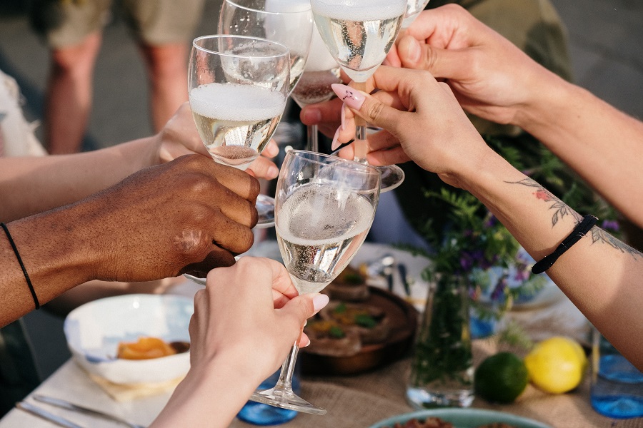 Summer Dinner Party Tips Close Up of People Making a Toast