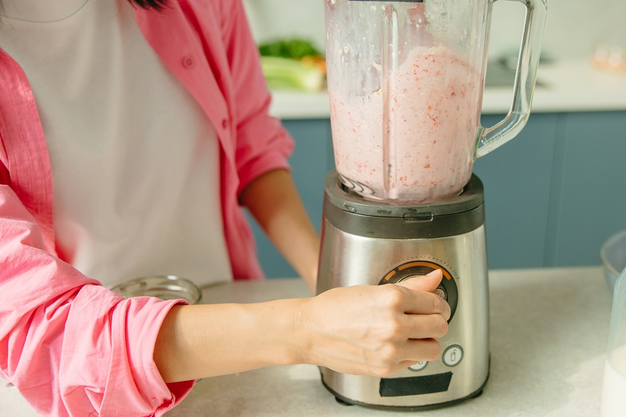 Frozen Cocktails Close Up of a Woman Using a Blender to Make a Drink