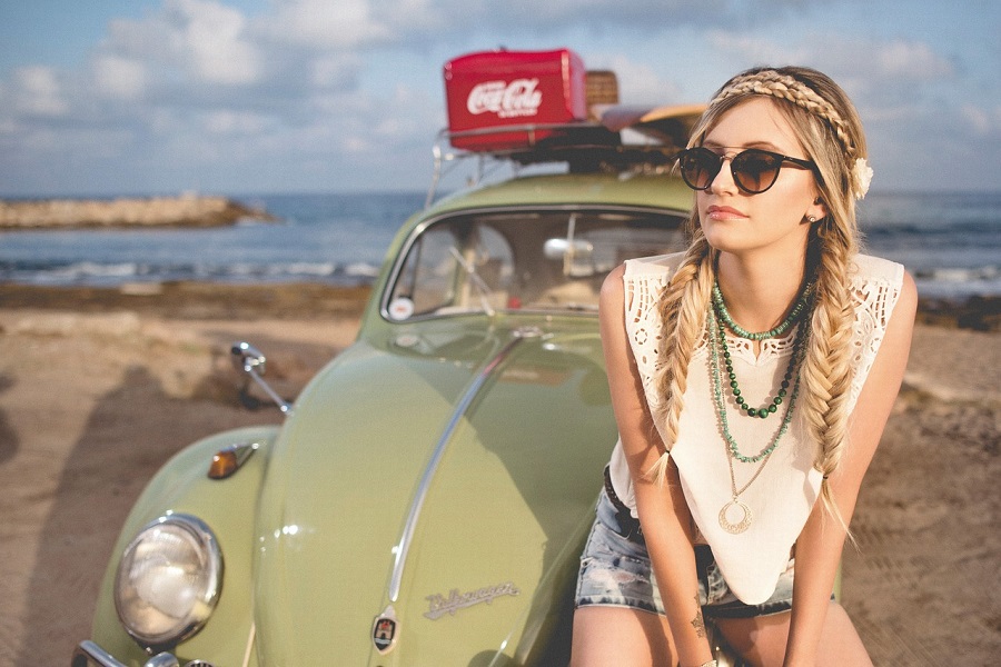 Recipes for Hippie Parties a Woman Dressed Like a Hippie Sitting on the Front of a VW Bug
