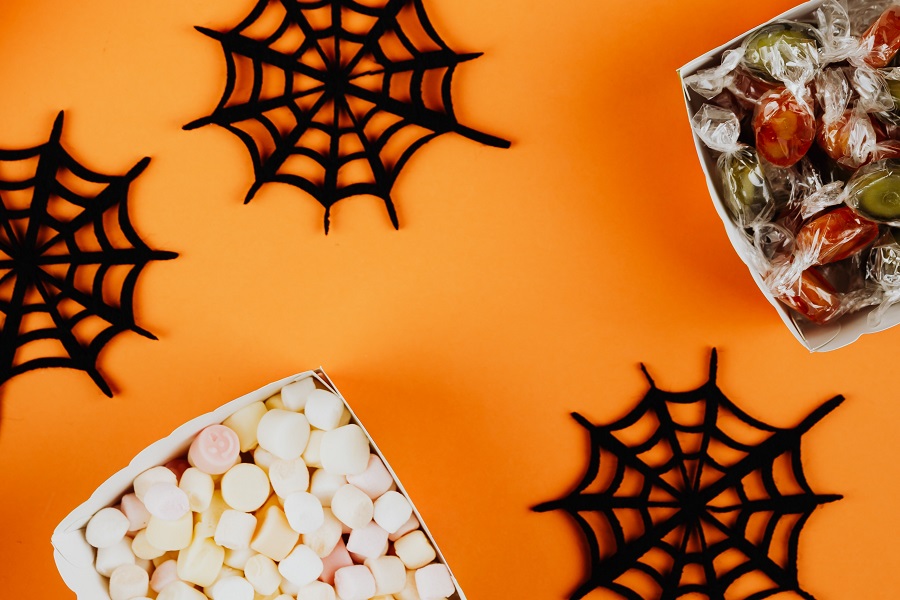 Indoor Halloween Decor Ideas Close Up of Spider Webs and Two Bowls of Candy on an Orange Surface
