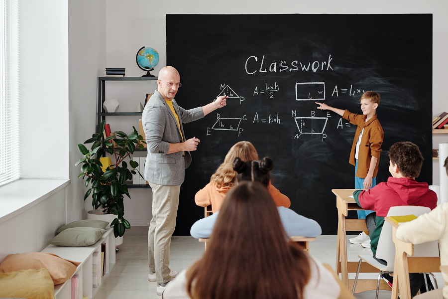 Best Back to School Party Ideas a Teacher Standing Nect to a Chalkboard with Students in the Class