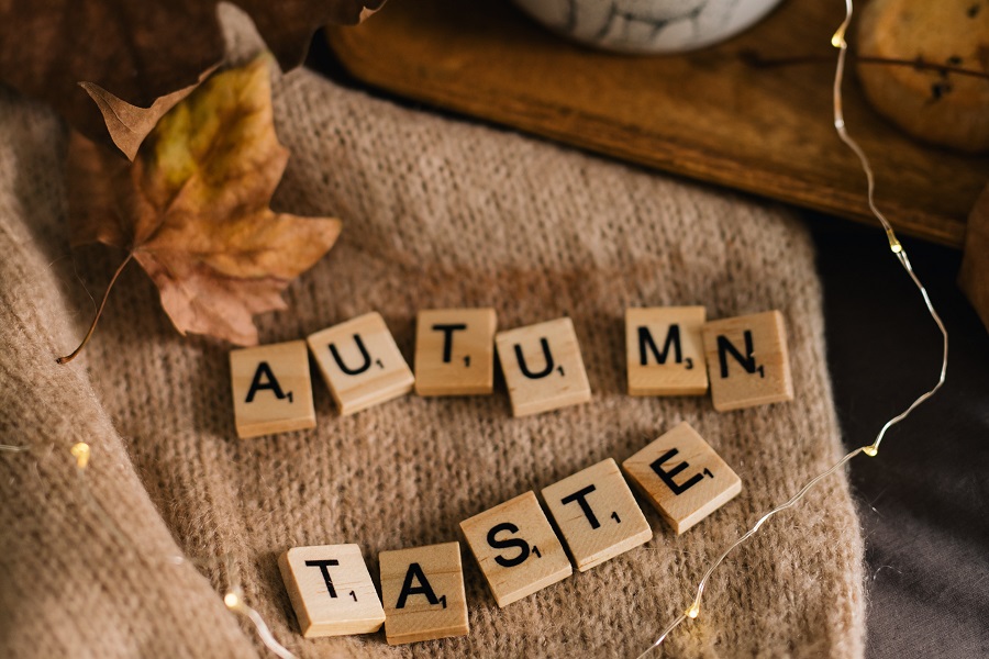 Cozy Fall Kitchen Decor Letter Tiles Spelling Out Autumn Taste On a Towel with Fall Leaves Around