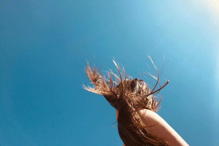 Easy Back to School Hairstyles a Woman with Long hair Twirling it in Sunlight