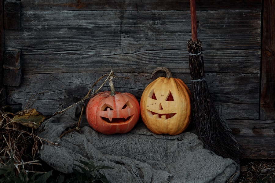 Halloween Fireplace Mantel Decor Ideas Two Jack-O-Lanterns Sitting on a Dusty Blanket Next to a Witch's Broom