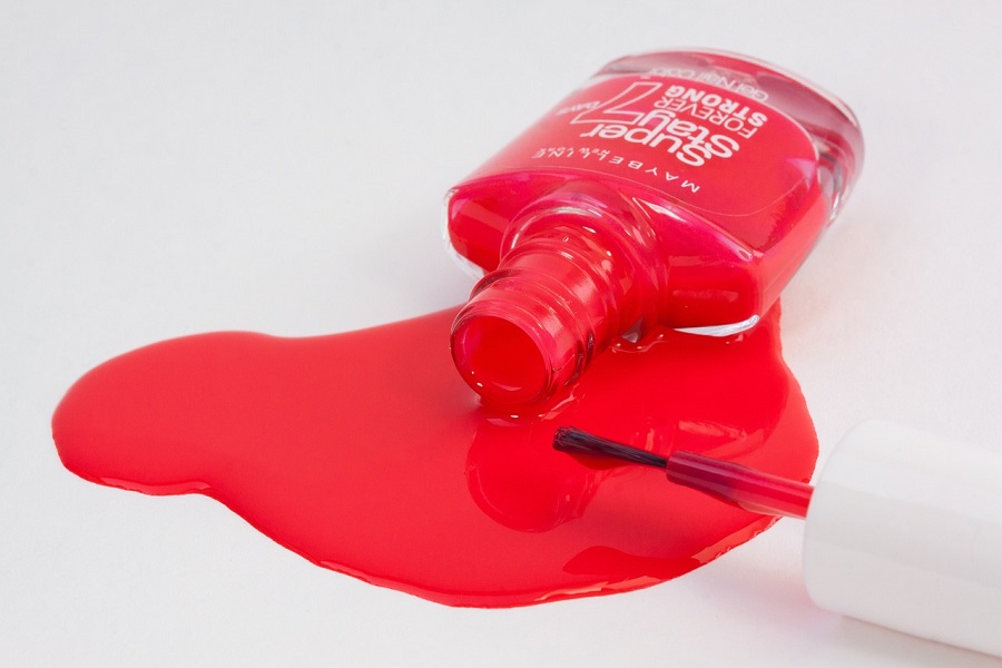 Halloween Nails Ideas for All Ages a Spilled Bottle of Red Nail Polish on a White Table
