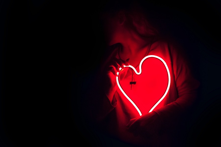 Cute Hoco Signs a Person Holding a Lit Neon Heart-Shaped Light in a Dark Room