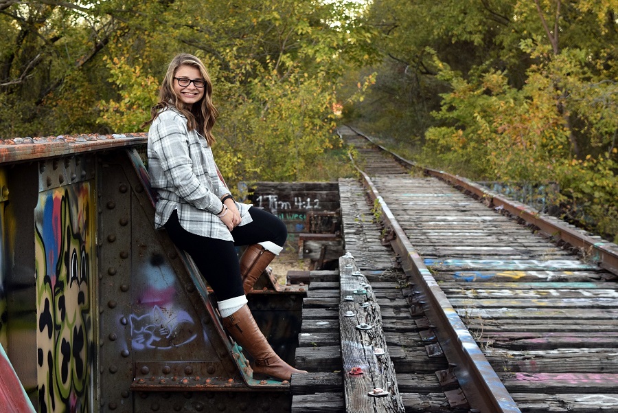 Cute Hoco Signs a Senior Photo of a Girl Standing Near Train Tracks