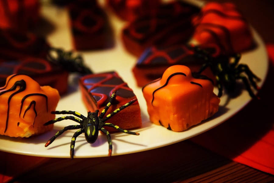 Halloween Candy Memes a Serving Tray Filled with Gourmet Chocolates in Orange and Black with Plastic Spiders Placed Around the Chocolates