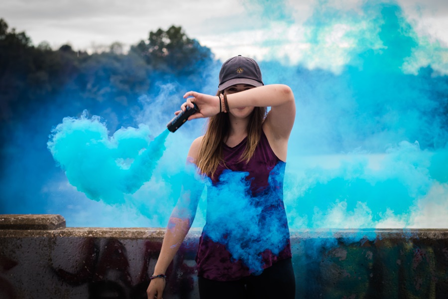 Blue Jello Shot Recipes Woman Holding a Smoke Bomb with blue Smoke Outside