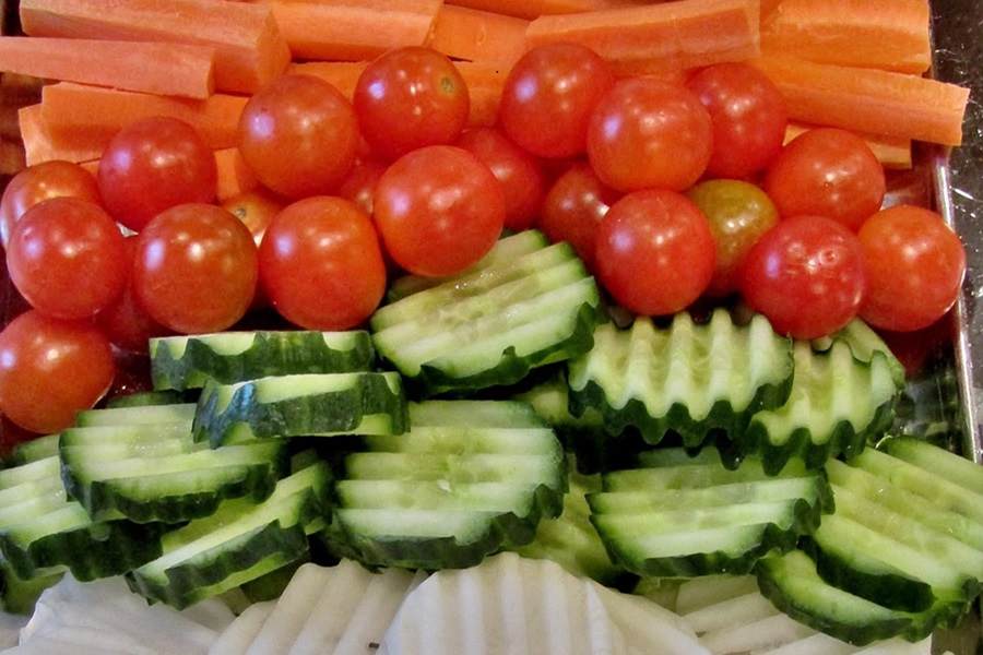 What to Serve with Tzatziki Dip a Serving Tray Filled with Sliced Veggies Including Cucumber, Tomatoes, and Carrots