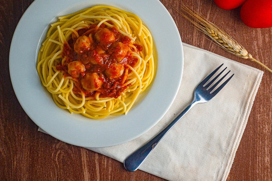 Easy Instant Pot Spaghetti and Meatballs Recipes Overhead of a Plate of Spaghetti and Meatballs Next to a Fork on a Napkin