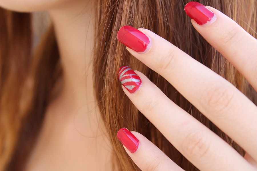 Memorial Day Nail Designs Close Up of a Woman's Hand with Red Fingernails Against Her Hair