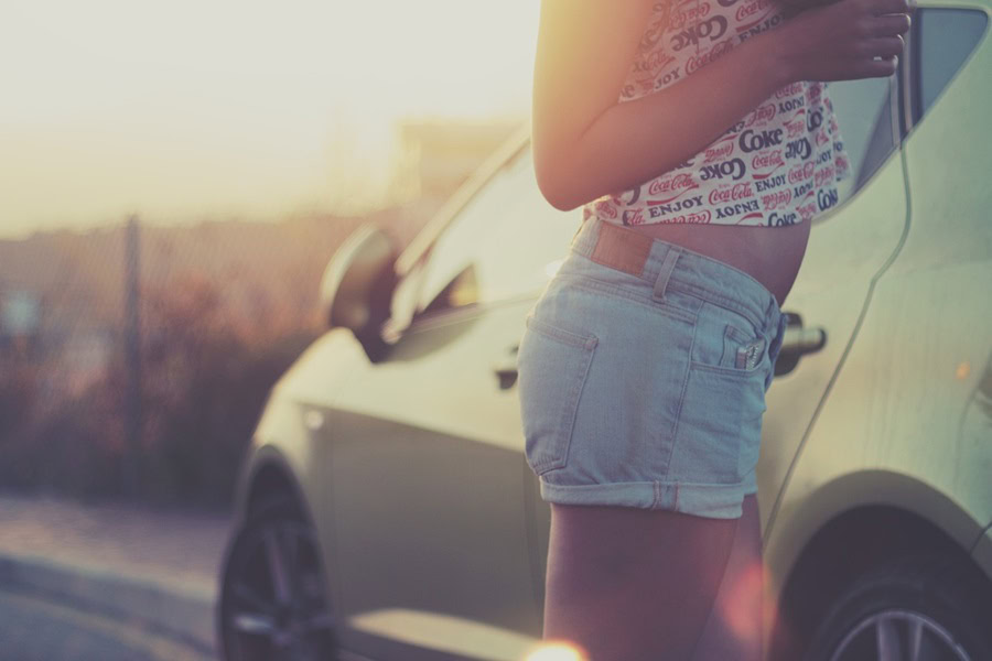 Summer Outfit Inspo Ideas Close Up of a Woman's Denim Shorts Standing Next to a Car