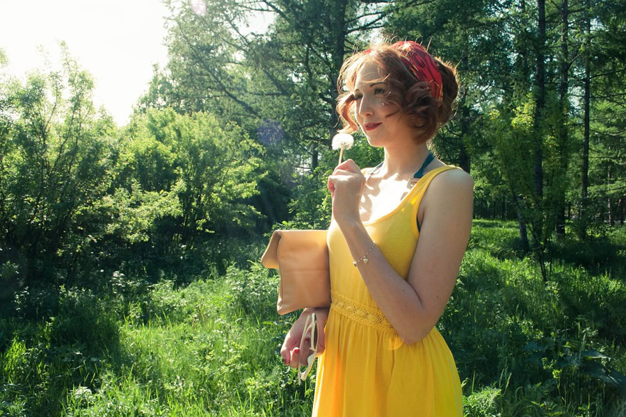 Summer Outfit Inspo Ideas a Woman Standing Outside Wearing a Yellow Dress and Smelling a Flower