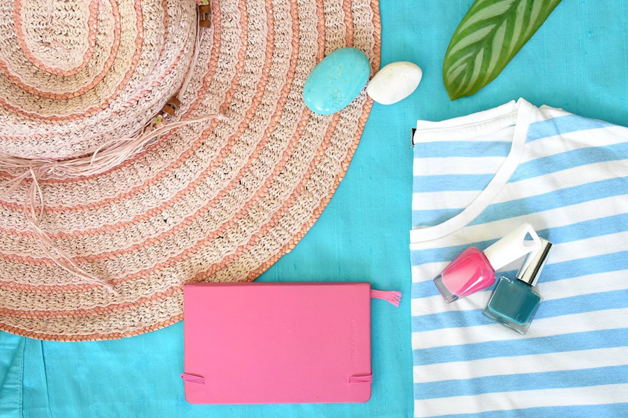 Summer Outfit Inspo Ideas a hat Next to a Purse and a Dress on a Blue Surface