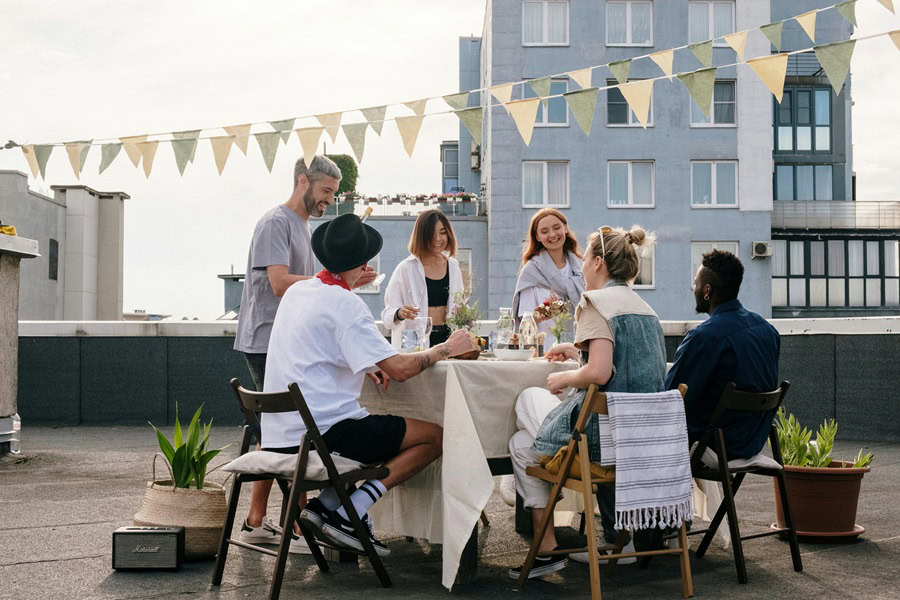 Casual Dinner Party Menu Ideas People Having a Meal at a Table on a Rooftop in a City