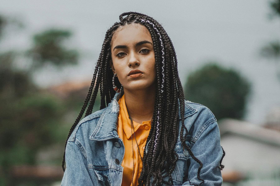 Gorgeous Goddess Braids with Curls on Natural Hair a Woman with Braids Wearing a Jean Jacket Sitting Outside
