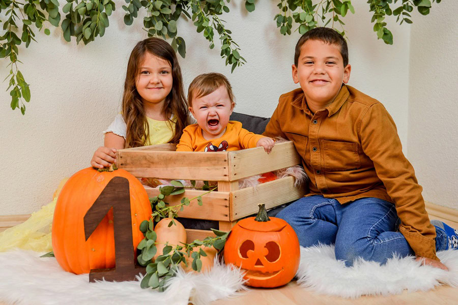 1st Birthday Party Ideas for Boys Three Kids with Pumpkins That Have the Number One on Them and a Crying Baby Boy in a Wooden Crate in a Portrait Studio