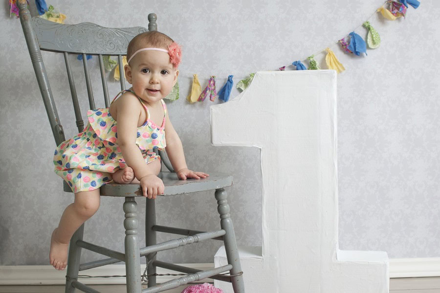 1st Birthday Party Ideas for Girls a Little Girl on a Chair with a Giant Number One Sign Next to it